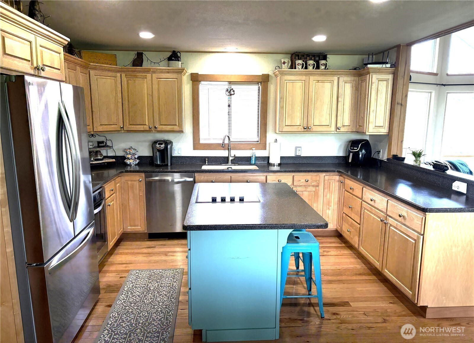 8 Mundinger Lane Omak, WA 98841 - Photo 9 of 37 a kitchen with stainless steel appliances granite countertop a refrigerator a sink dishwasher a stove and white countertops with wooden floor