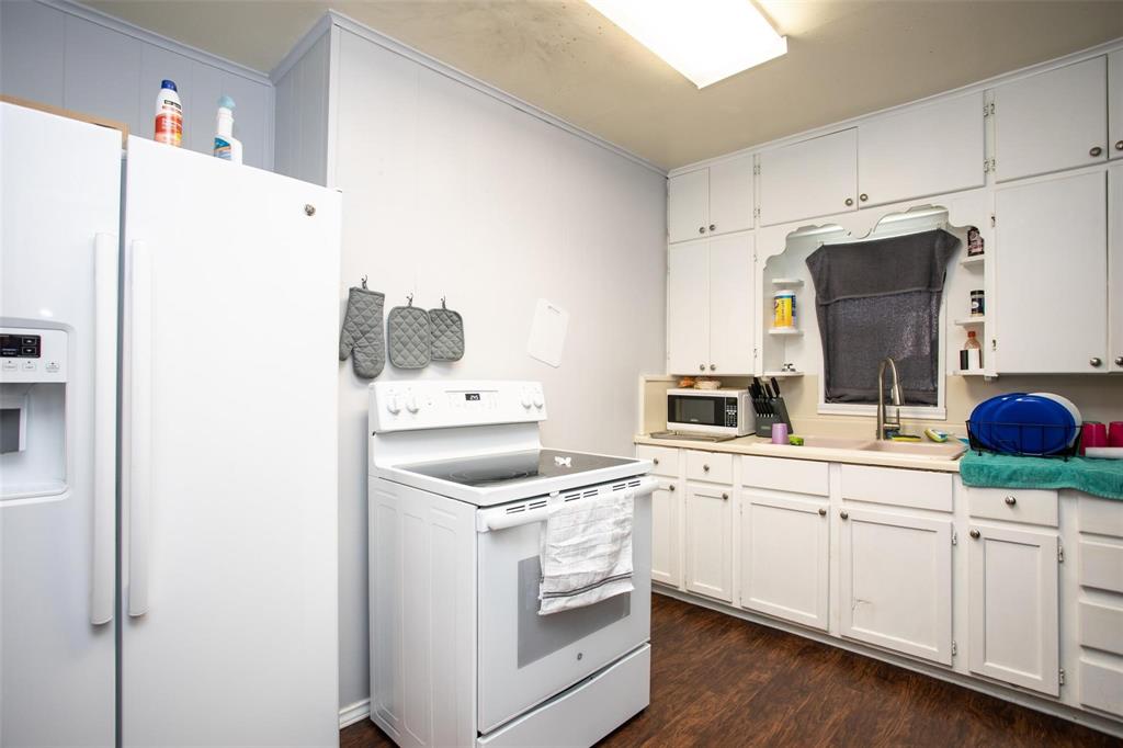 716 Rocky Ridge Flatts Oak Ridge, TX 76240 - Photo 6 of 10 Kitchen with white appliances, open shelves, light countertops, and white cabinets
