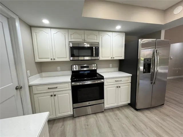 a kitchen with stainless steel appliances a refrigerator sink and microwave