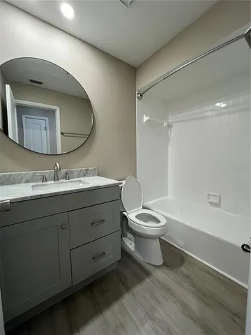 a bathroom with a toilet sink double vanity and bathtub