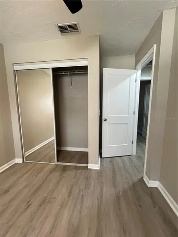 an empty room with wooden floor and closet