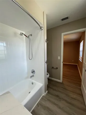 a bathroom with a tub shower vanity and a sink