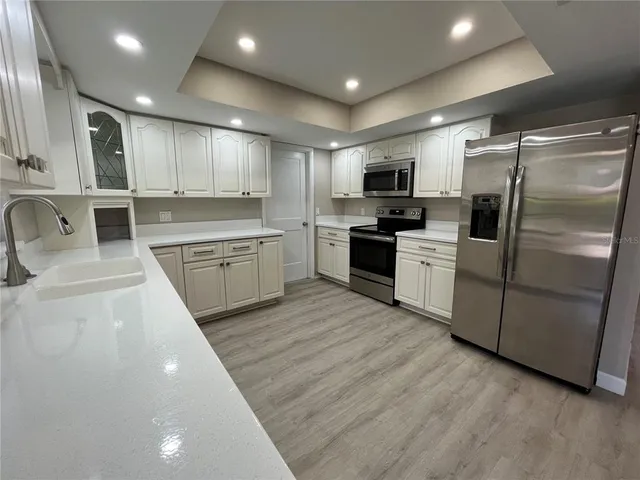 a large kitchen with cabinets stainless steel appliances and a counter top space