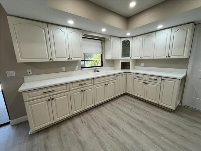 a kitchen with sink cabinets and wooden floor