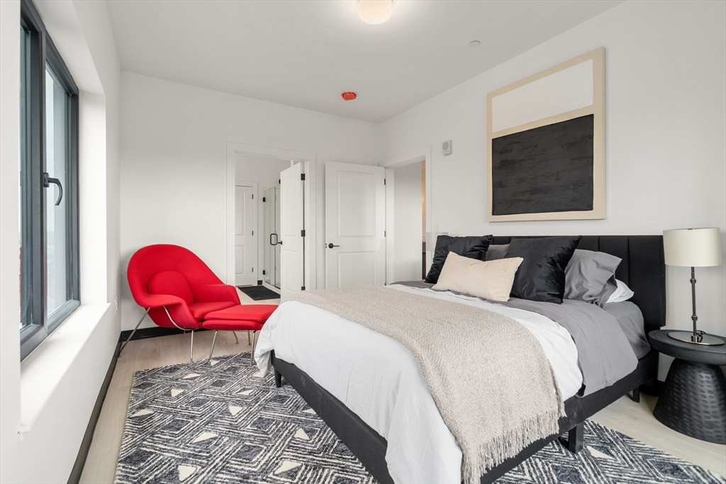 600 Broadway, Unit 512 Chelsea, MA 02150 - Photo 8 of 30 a bedroom with a bed and wooden floor