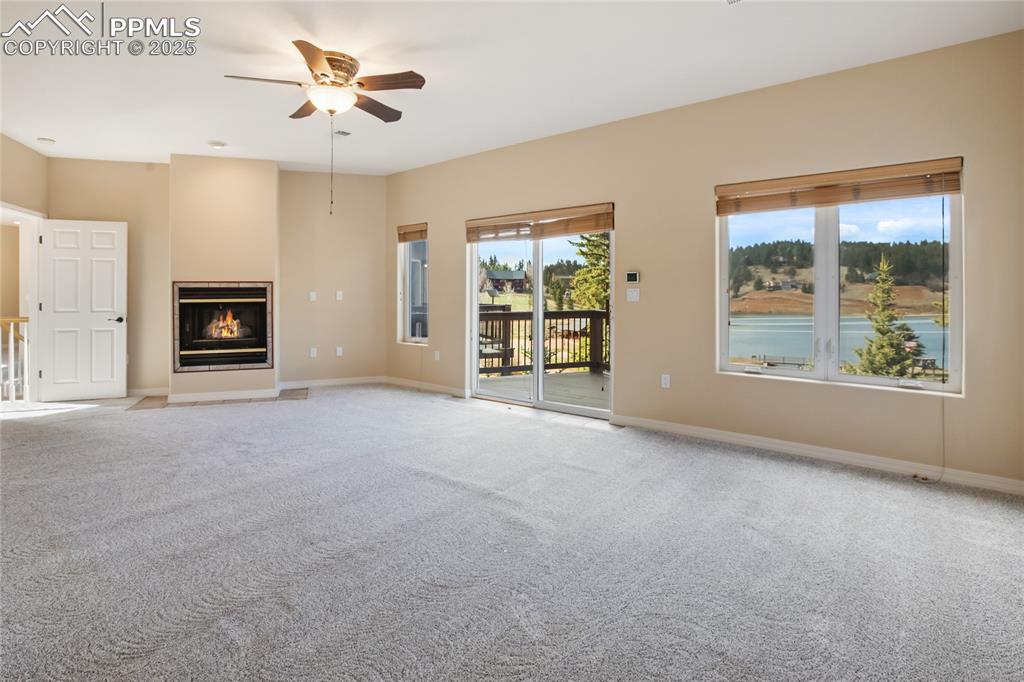1427 Spring Valley Drive Divide, CO 80814 - Photo 43 of 50 an empty room with windows fireplace and a chandelier