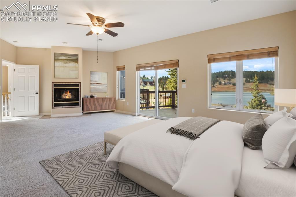 1427 Spring Valley Drive Divide, CO 80814 - Photo 44 of 50 a bedroom with a large bed a fireplace and windows