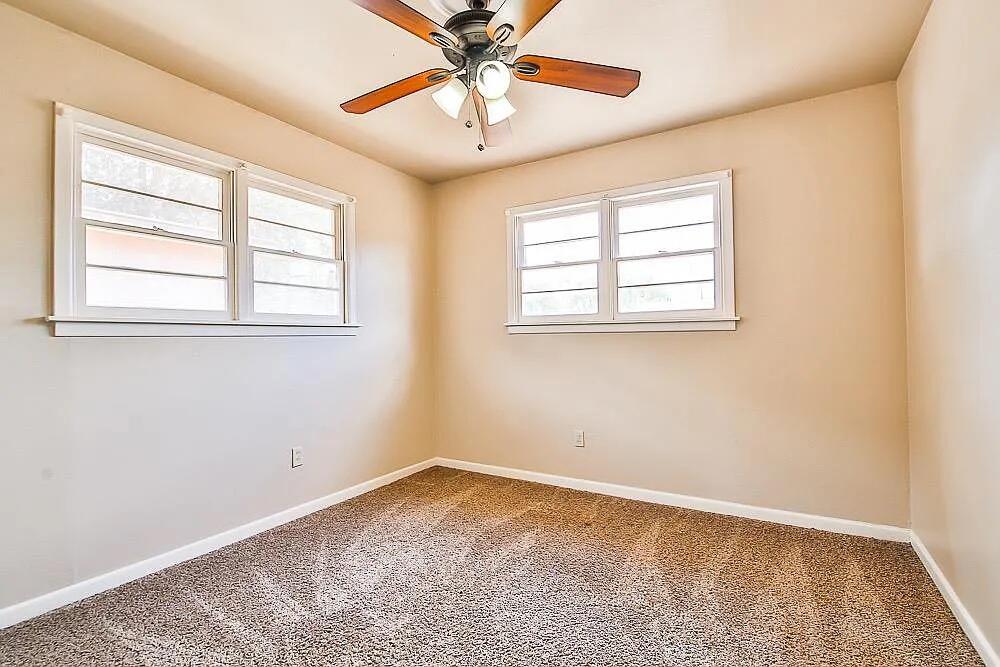 2714 40th Street Lubbock, TX 79413 - Photo 7 of 14 an empty room with a window and a fan