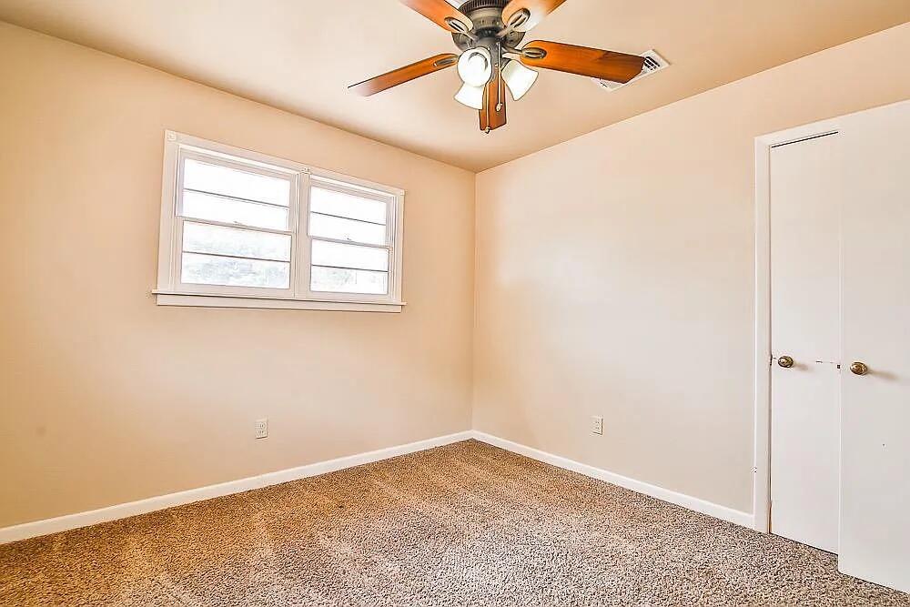 2714 40th Street Lubbock, TX 79413 - Photo 9 of 14 an empty room with a window and a fan