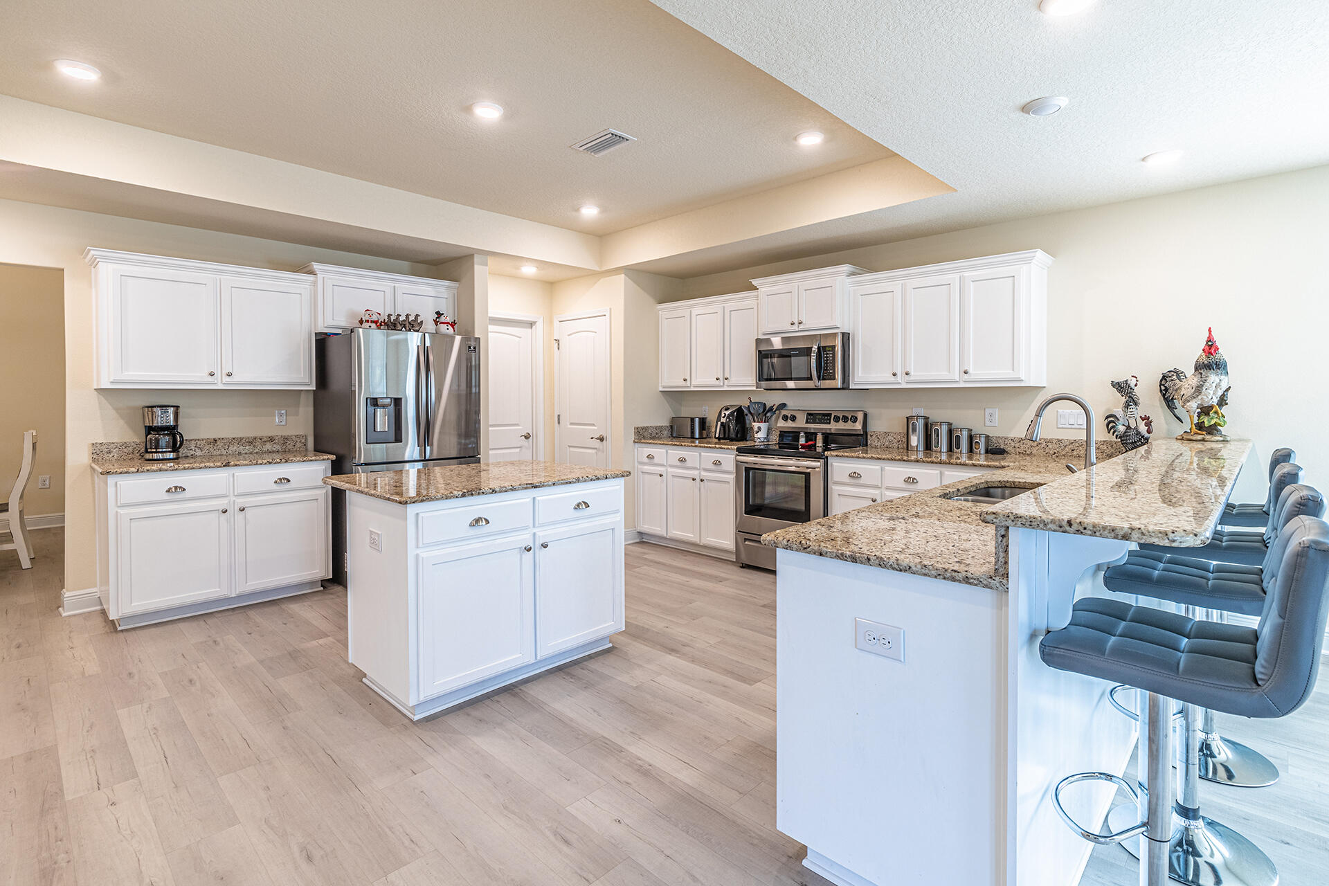 3639 Ranch Drive Crestview, FL 32539 - Photo 16 of 40 a kitchen with kitchen island granite countertop wooden cabinets and white appliances