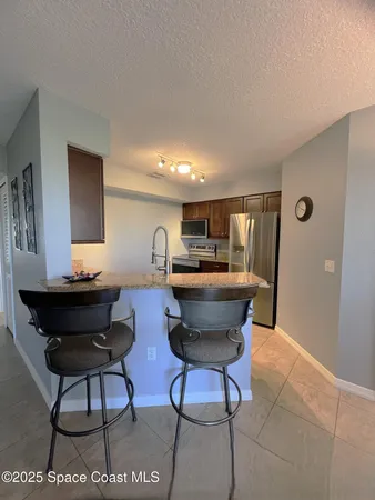 a kitchen with stainless steel appliances granite countertop a stove a refrigerator and a microwave