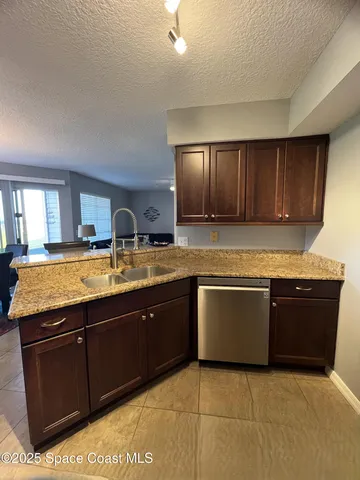 a large kitchen with granite countertop a sink and cabinets