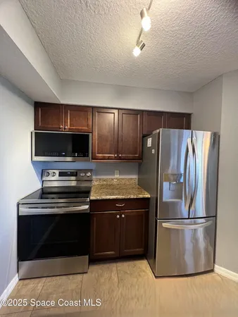 a large kitchen with granite countertop a sink and cabinets