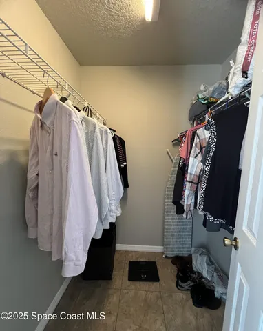 a view of walk in closet with clothes and shoes