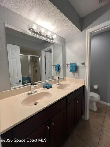 a bathroom with a double vanity sink and a toilet