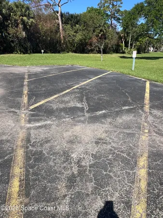a front view of a house with a yard and parking