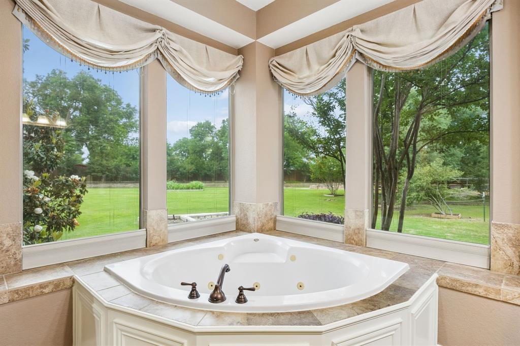 5802 Corinth Chapel Road Parker, TX 75002 - Photo 19 of 40 This jetted tub is surrounded by windows that overlook the gorgeous backyard. No privacy worries with motorized shades! Tile surround offers space for lotions and potions.