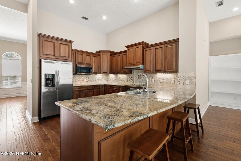 337 South Mill View Way Ponte Vedra Beach, FL 32082 - Photo 19 of 55 a kitchen with stainless steel appliances granite countertop a table chairs sink refrigerator and microwave