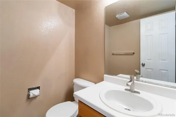 a bathroom with a sink a toilet and mirror