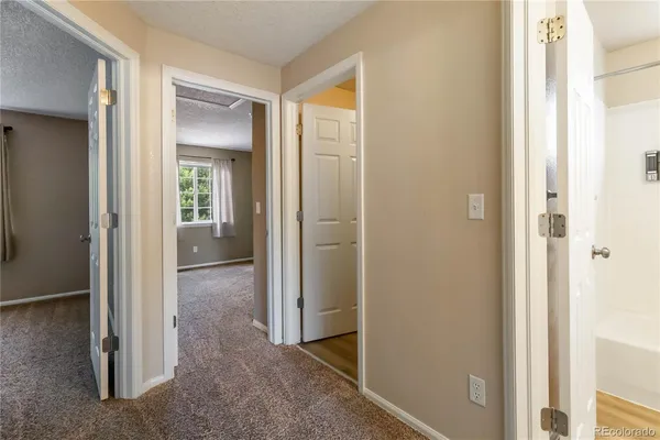 a view of a hallway with closet and a bathroom