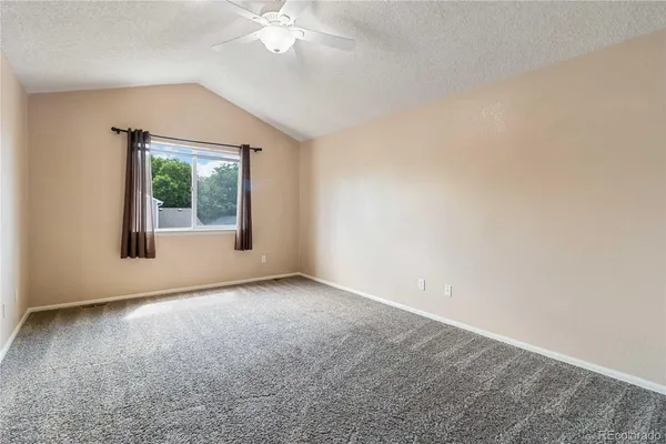 an empty room with windows and fan