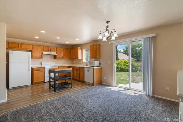 a view of kitchen with furniture and refrigerator