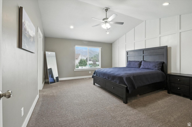 1055 West 2500th Street South Logan, UT 84321 - Photo 17 of 53 Spacious primary bedroom featuring vaulted ceilings with recessed lighting, a ceiling fan, plush carpet flooring, and a large window