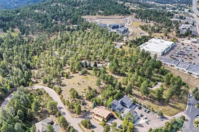 an aerial view of residential house with green space and trees all around