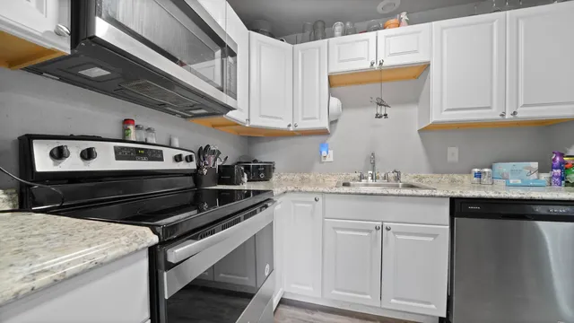 a kitchen with stainless steel appliances granite countertop a sink and cabinets