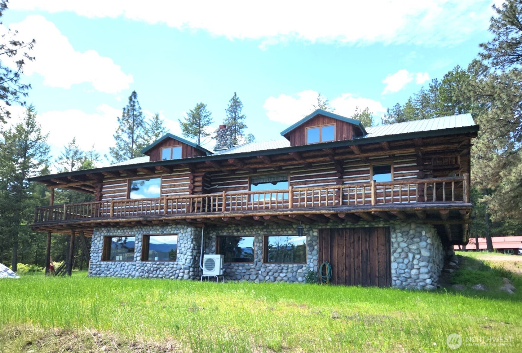 a view of a brick house with a yard potted plants and a large tree