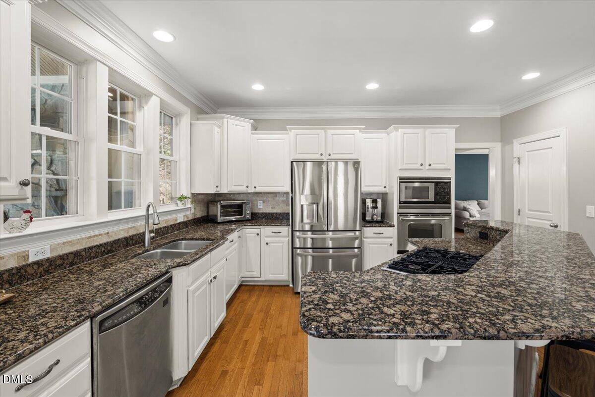 7828 Percussion Drive Apex, NC 27539 - Photo 20 of 88 a kitchen with stainless steel appliances granite countertop a sink stove and refrigerator