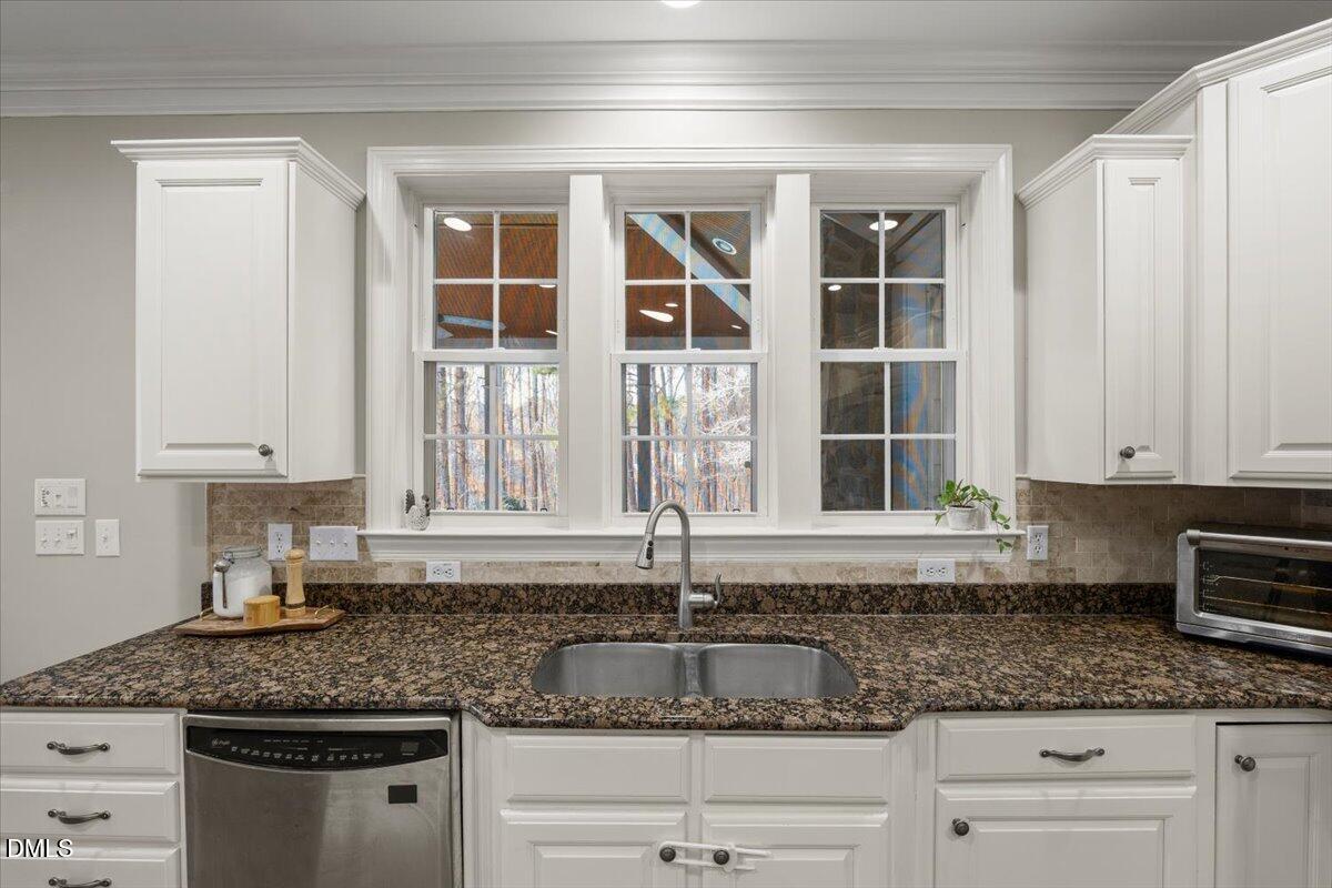 7828 Percussion Drive Apex, NC 27539 - Photo 21 of 88 a kitchen with granite countertop a sink and cabinets