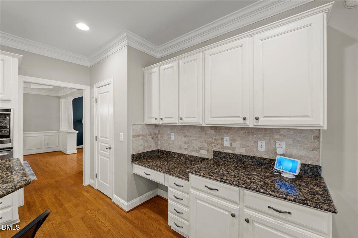 7828 Percussion Drive Apex, NC 27539 - Photo 27 of 88 a kitchen with granite countertop white cabinets and stainless steel appliances