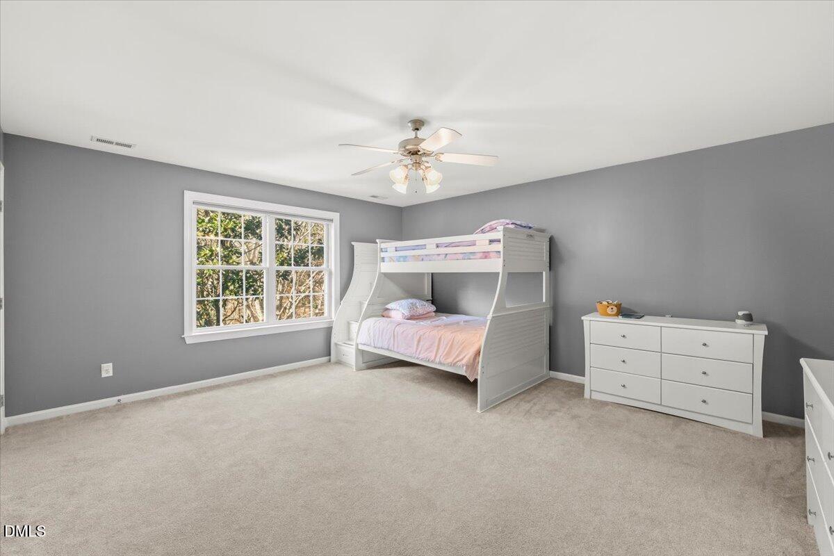 7828 Percussion Drive Apex, NC 27539 - Photo 57 of 88 a bedroom with a bed and a ceiling fan