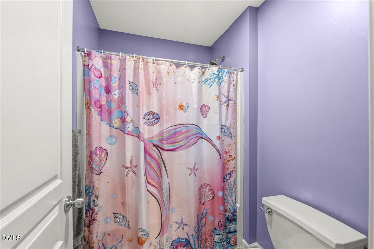 7828 Percussion Drive Apex, NC 27539 - Photo 61 of 88 a bathroom with a bathtub and shower curtain