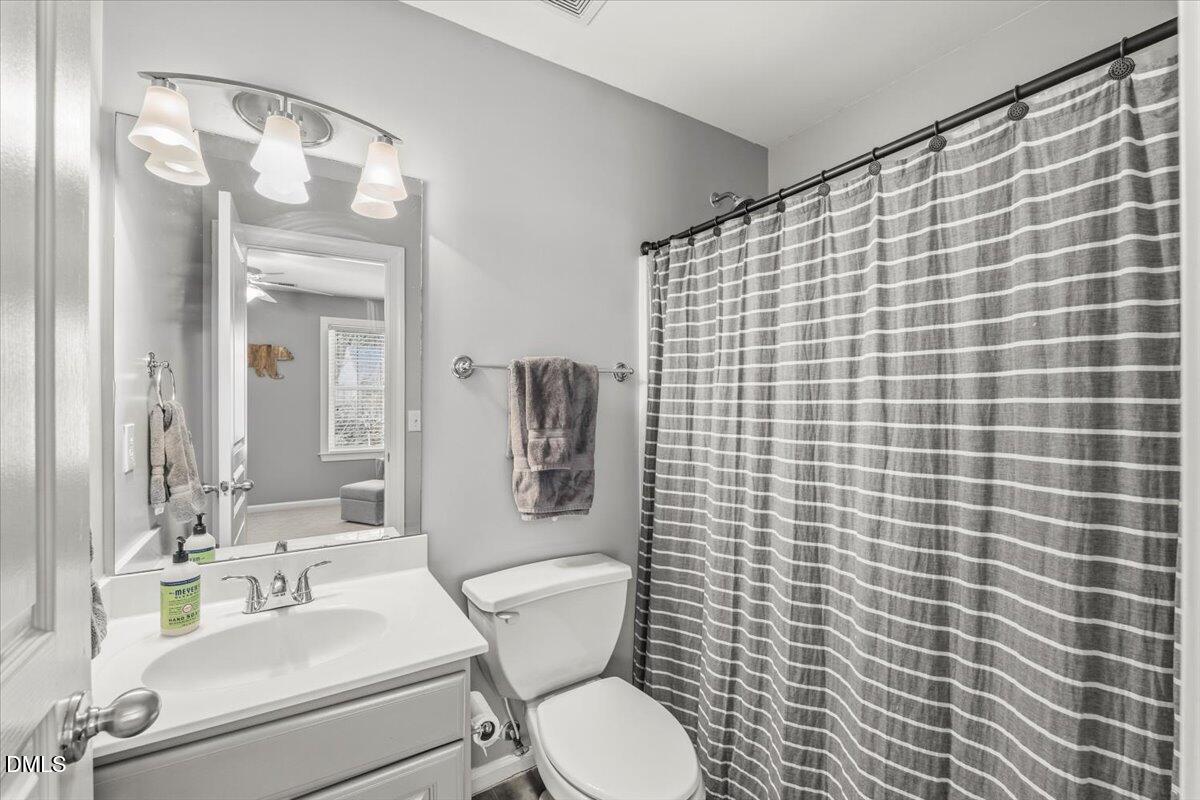 7828 Percussion Drive Apex, NC 27539 - Photo 64 of 88 a bathroom with a sink mirror vanity and toilet
