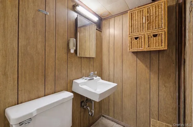 a bathroom with a sink a toilet and mirror