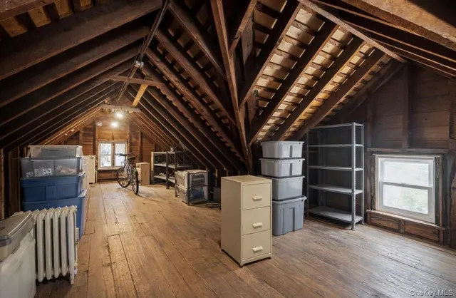 a view of an empty room with wooden floor and windows