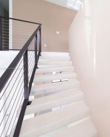 a view of a hallway with wooden floor and stairs