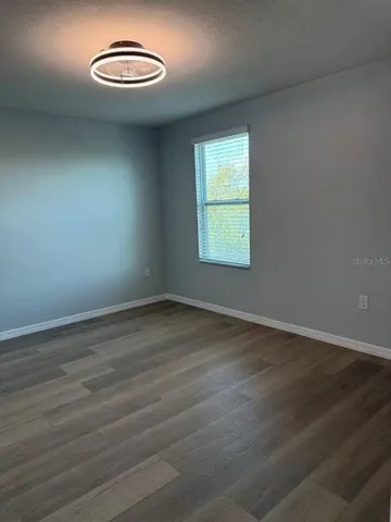an empty room with wooden floor and a window