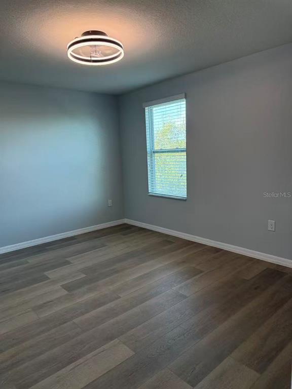 2114 Rockmart Loop Tavares, FL 32778 - Photo 12 of 18 an empty room with wooden floor and a window