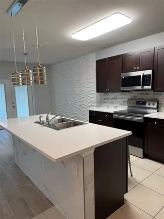 a kitchen with a sink a microwave and cabinets