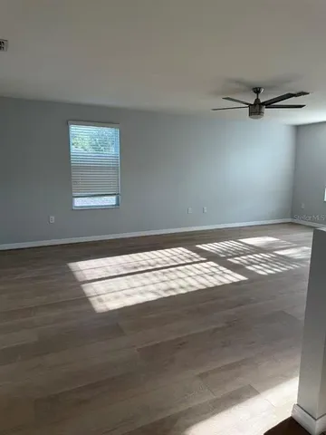 a view of a room with wooden floor and fan