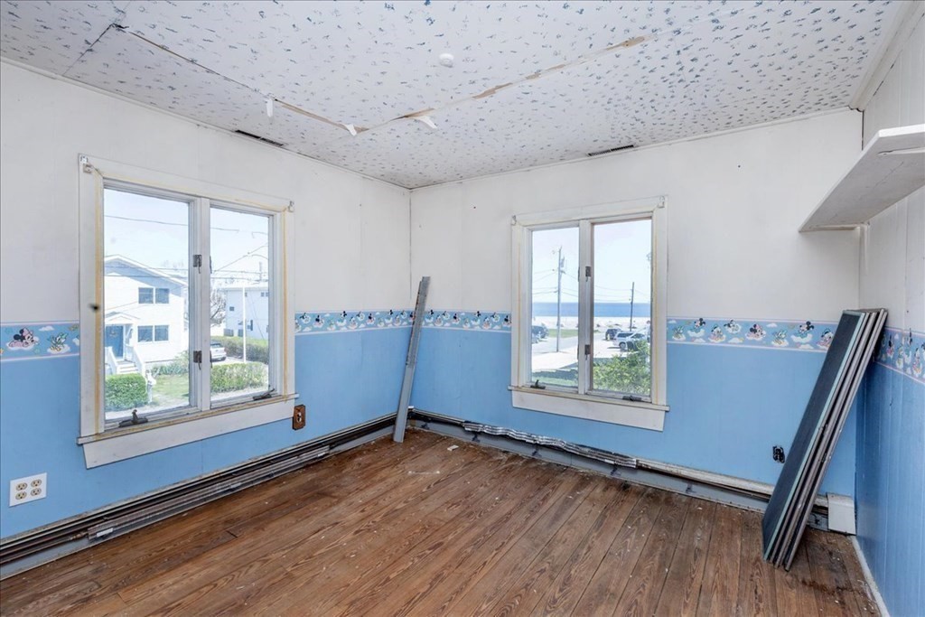 88 Marion Road Scituate, MA 02066 - Photo 13 of 41 a view of an empty room with a window and wooden floor