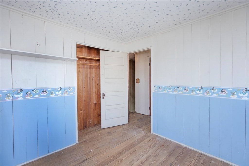 88 Marion Road Scituate, MA 02066 - Photo 15 of 41 an empty room with wooden floor and cabinet