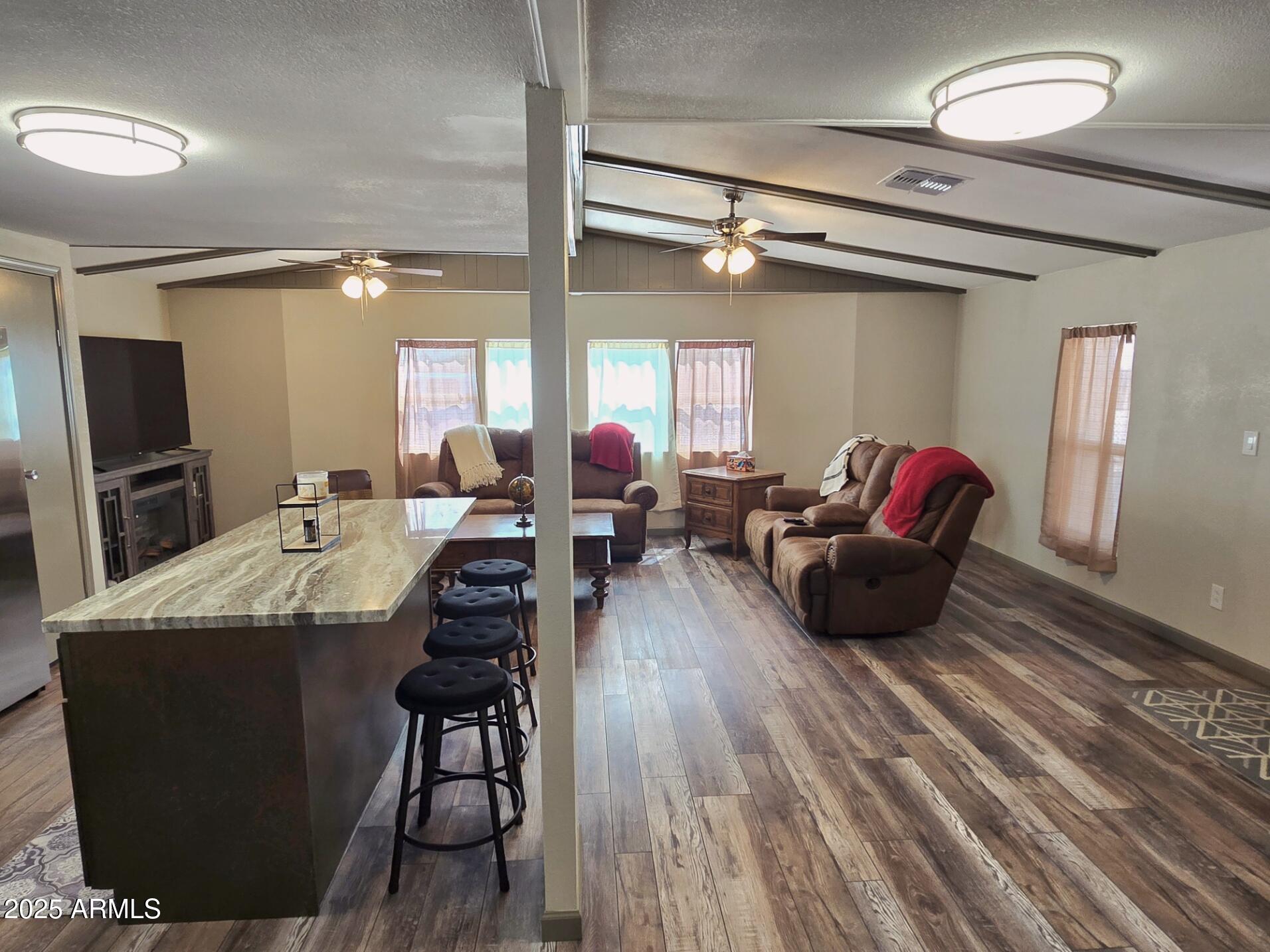 2900 West Superstition Boulevard, Unit 46 Apache Junction, AZ 85120 - Photo 11 of 26 a living room with furniture a flat screen tv and a wooden floor