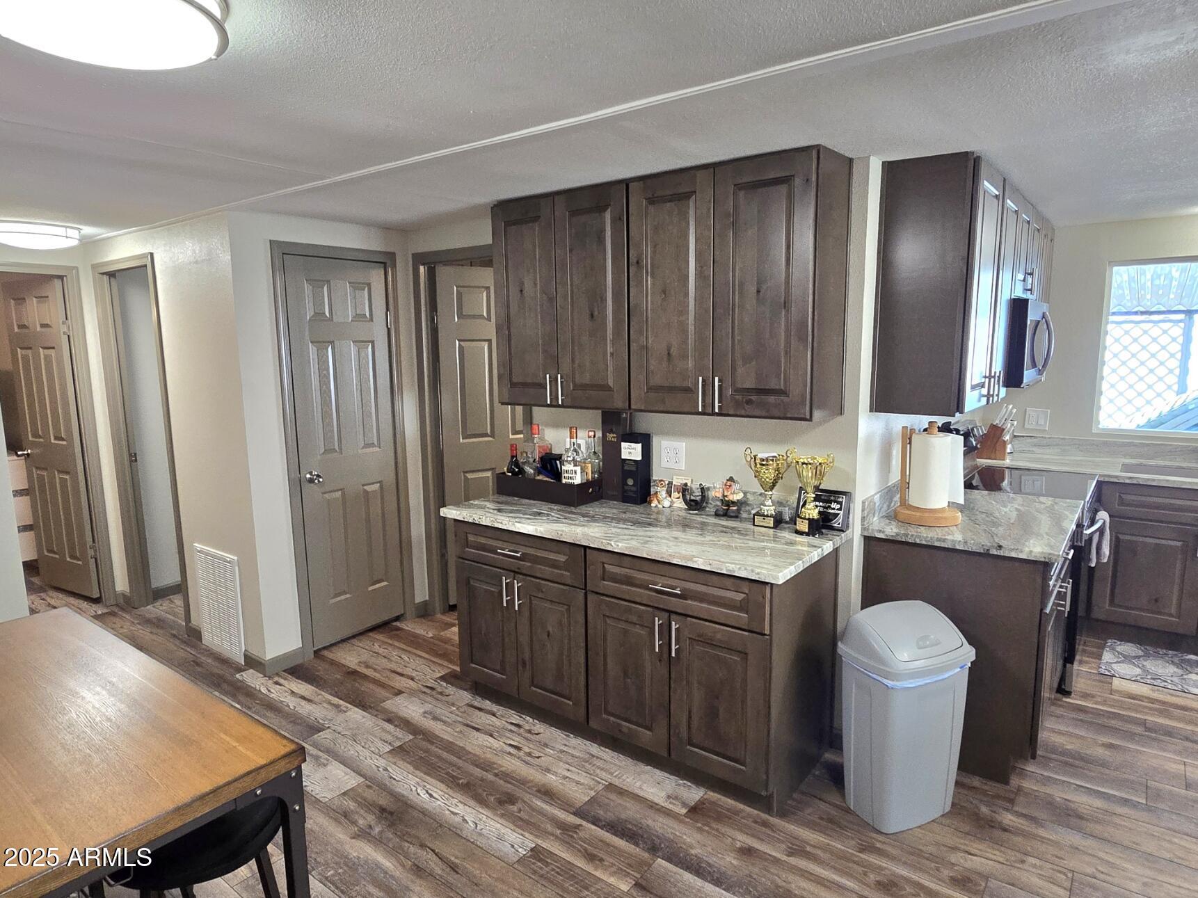 2900 West Superstition Boulevard, Unit 46 Apache Junction, AZ 85120 - Photo 13 of 26 a kitchen with a table chairs sink and cabinets