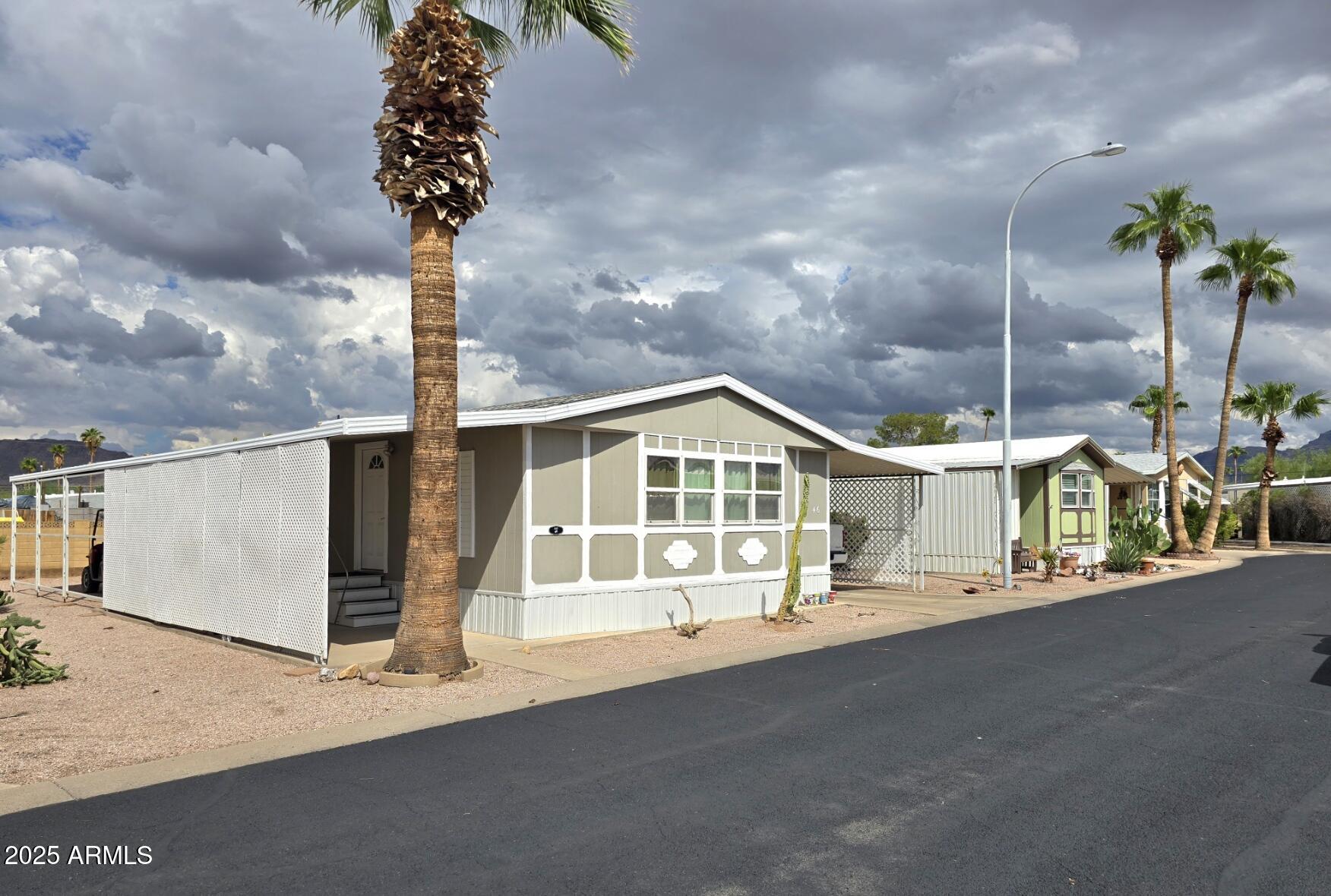2900 West Superstition Boulevard, Unit 46 Apache Junction, AZ 85120 - Photo 3 of 26 a front view of a house with a garden and street view