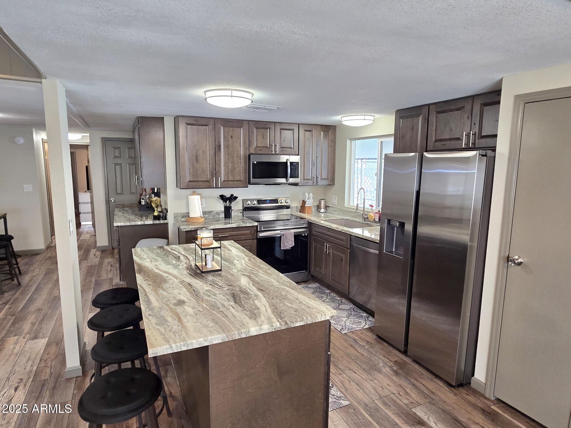 2900 West Superstition Boulevard, Unit 46 Apache Junction, AZ 85120 - Photo 8 of 26 a kitchen with stainless steel appliances granite countertop a refrigerator a stove a sink a microwave and a refrigerator