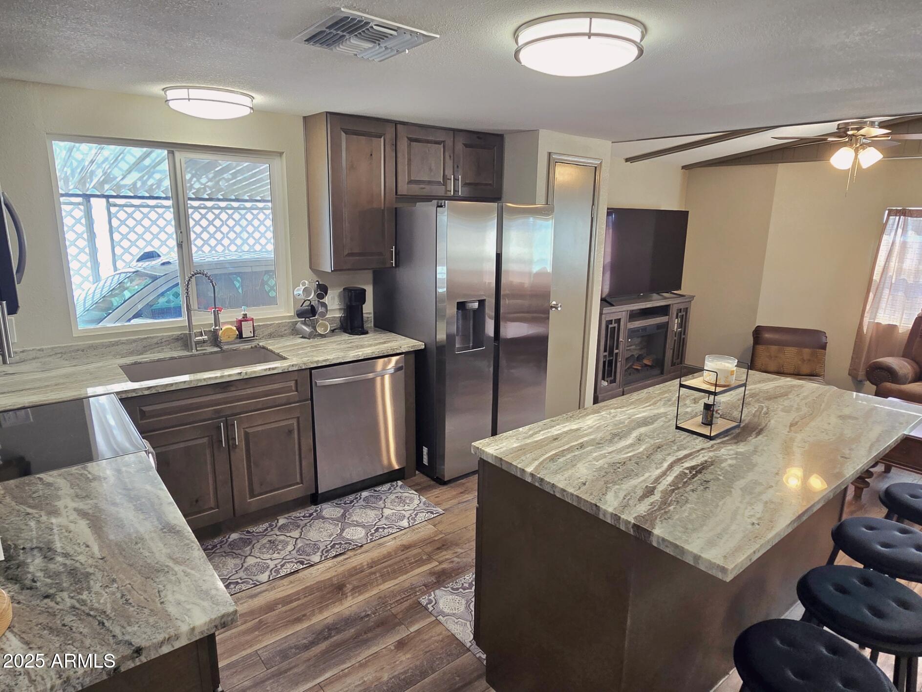 2900 West Superstition Boulevard, Unit 46 Apache Junction, AZ 85120 - Photo 10 of 26 a kitchen with stainless steel appliances granite countertop a sink stove and refrigerator